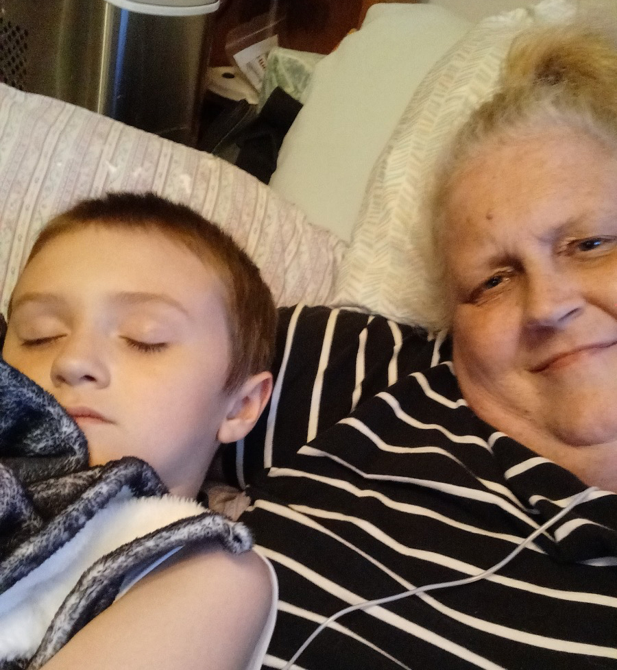 A photo of an elderly woman taking a picture with her young grandson.