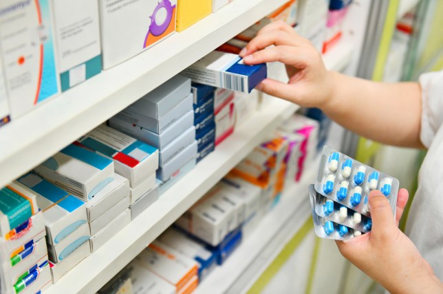 Pharmacist holding medicine box and capsule pack